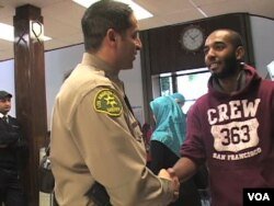 Sherif Morsi, Wakil Sheriff di Los Angeles yang juga seorang Muslim ini, beramah-tamah dengan seorang jemaah sebuah masjid di LA.
